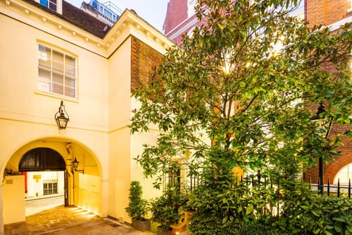 Cannon Street, East London: Building entrance with arch and lantern at dusk