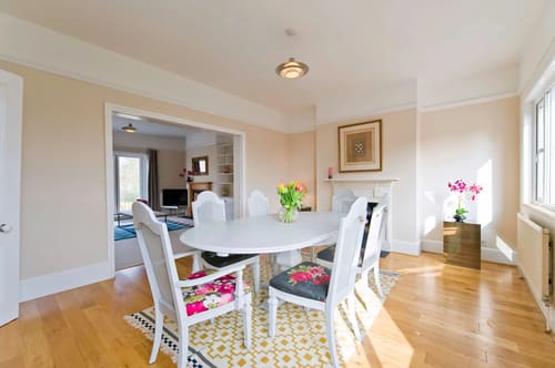 The Claygate Apartments, Claygate: Dining room with white chairs and patterned rug