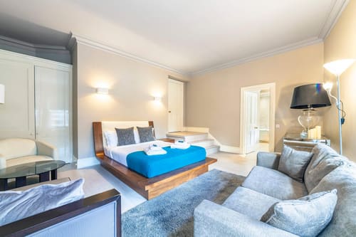 High-end 4-bedroom luxury apartment in W1K, Mayfair: Open-plan bedroom and sitting area with blue bedspread