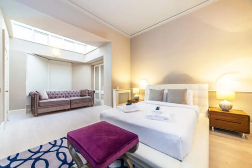 High-end 4-bedroom luxury apartment in W1K, Mayfair: Bedroom with purple ottoman and skylight