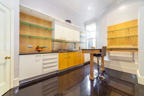 High-end 4-bedroom luxury apartment in W1K, Mayfair: Kitchen with breakfast bar and glass shelving