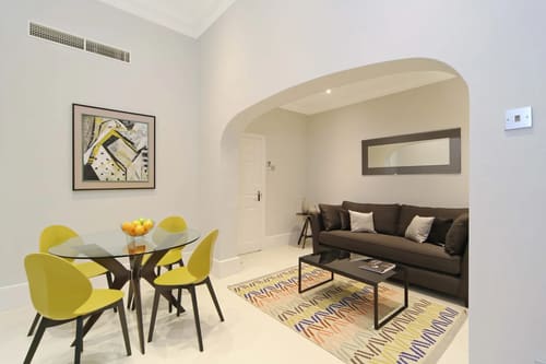 Queensgate Court, Kensington: Living room with yellow dining chairs and archway