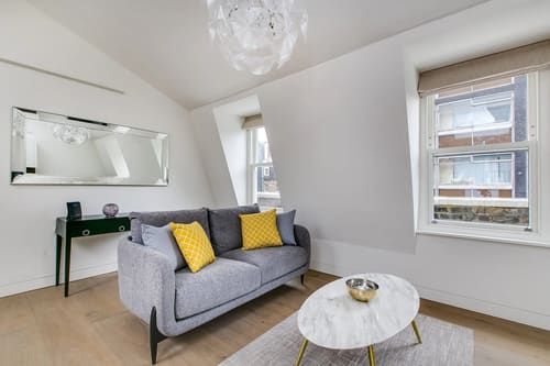 Marylebone Lane Residences, Marylebone: Living room with grey sofa and yellow cushions