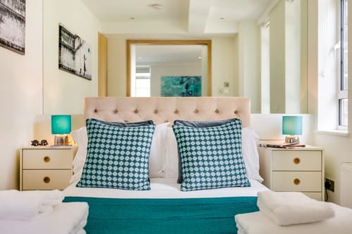 Nell Gwynn Chelsea Apartments, Kensington: Bed with houndstooth cushions and teal throw