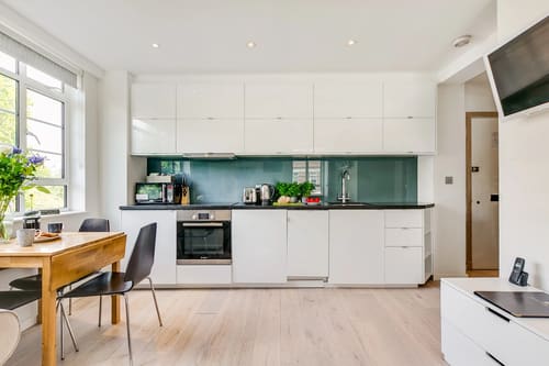 Nell Gwynn Chelsea Apartments, Kensington: White kitchen with teal glass splashback