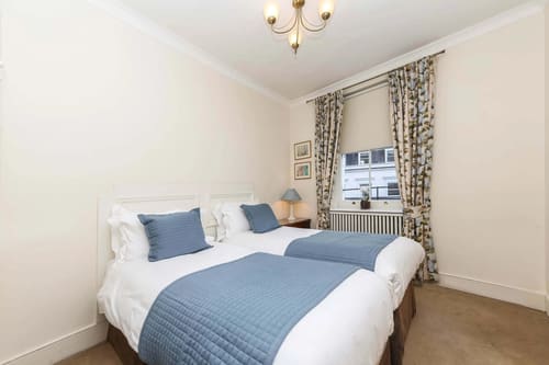 10 Curzon St, Mayfair: Twin bedroom with blue throws and sash window