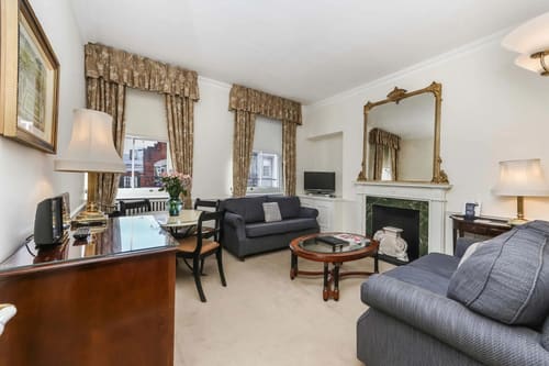 10 Curzon St, Mayfair: Living and dining room with fireplace and draped windows