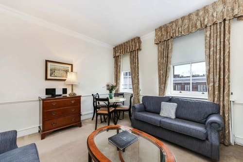 10 Curzon St, Mayfair: Living room with round dining table and swagged curtains