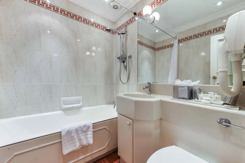 10 Curzon St, Mayfair: Bathroom with bath, shower and patterned border tiles