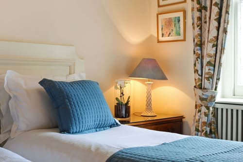 10 Curzon St, Mayfair: Bedside lamp and orchid beside a made-up bed