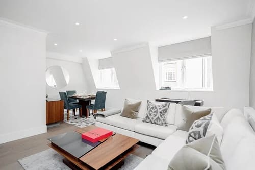 Mayfair Mews Apartment III, Mayfair: Living room with white sofa and dining area under a sloping ceiling