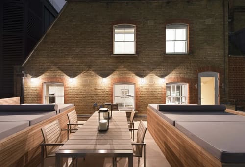 Grosvenor Hill, W1K, Mayfair: Roof terrace with long dining table and brick wall