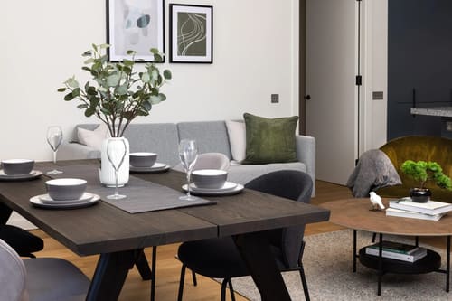 Ewer Street Apartments, Waterloo: Dining table set for four with grey sofa behind