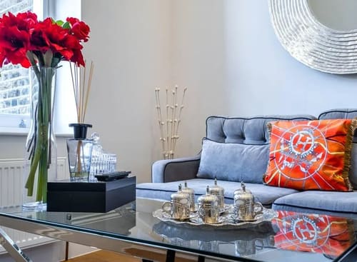 Ashburn Gardens, Kensington: Blue sofa with patterned cushions and a silver tea set