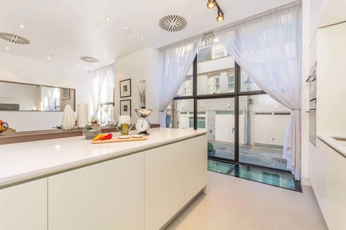 Kenrick Place, Marylebone: Kitchen island by full-height windows
