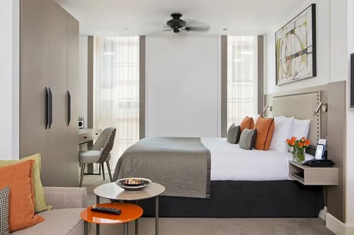 The Chancery Lane Chronicle, East London: Bedroom with ceiling fan and orange side table
