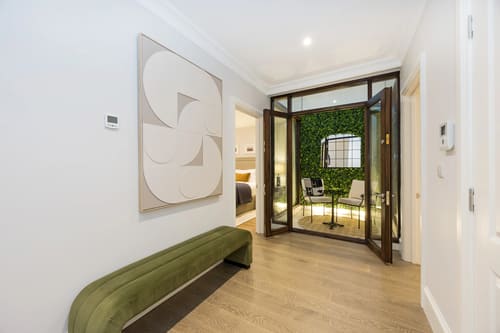 The Knightsbridge Apartments, Knightsbridge: Hallway with green bench and glass doors to courtyard