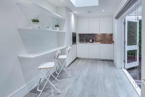 Green Street Residences, Mayfair: Kitchen with white units and folding chairs