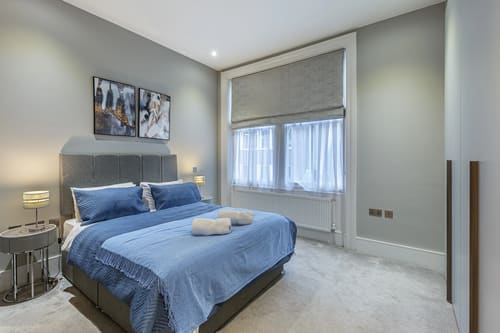 Green Street Residences, Mayfair: Bedroom with blue bedspread and window blinds