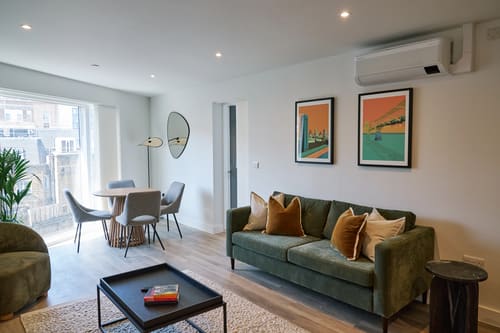 The Kings Cross Apartments, King's Cross: Living room with green sofa and dining table