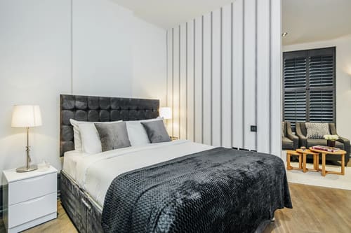 The Garrick Street Apartments, Covent Garden: Double bed with padded headboard and charcoal throw