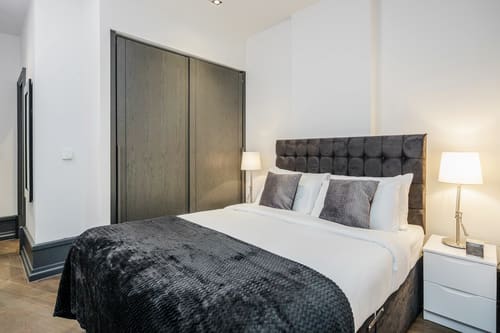 The Garrick Street Apartments, Covent Garden: Double bed with dark sliding wardrobe