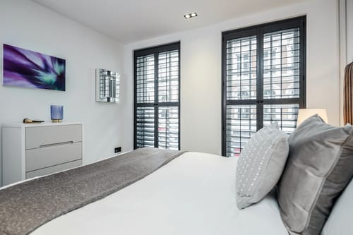 The Garrick Street Apartments, Covent Garden: Bed beside black-shuttered windows