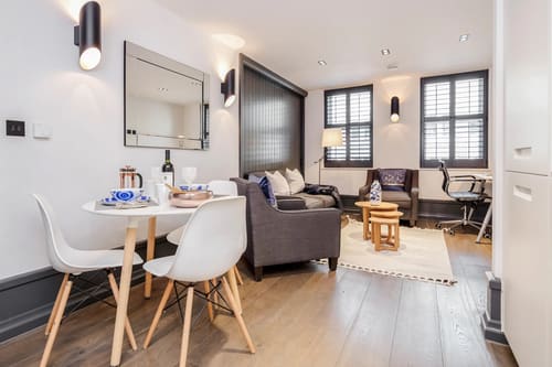 The Garrick Street Apartments, Covent Garden: Living room with dark sofas and white dining chairs