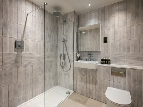 The Spitalfields Urban Rest Apartments, East London: Shower room with grey vertical tiles