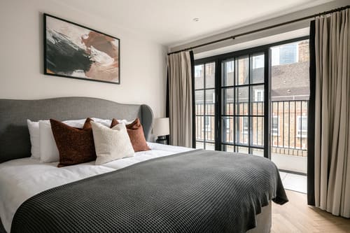 The Spitalfields Urban Rest Apartments, East London: Double bed with charcoal throw by French windows