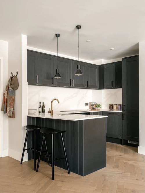 The Spitalfields Urban Rest Apartments, East London: Kitchen with charcoal cabinets and brass taps
