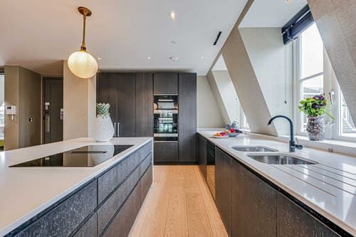The Westminster Residences, Westminster: Kitchen with dark wood units and sloped ceiling