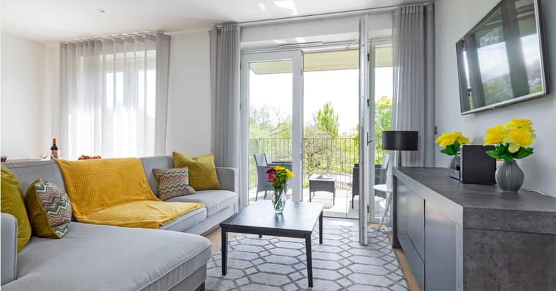 Phoenix Luxury Stays Battersea, Battersea: Three On Sphinx: Pale sofa with yellow cushions beside balcony doors, photo 1