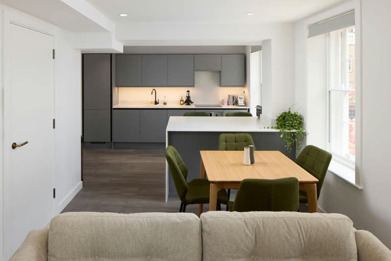 Beyond Soho, Soho: Sofa and dining table beside open-plan kitchen