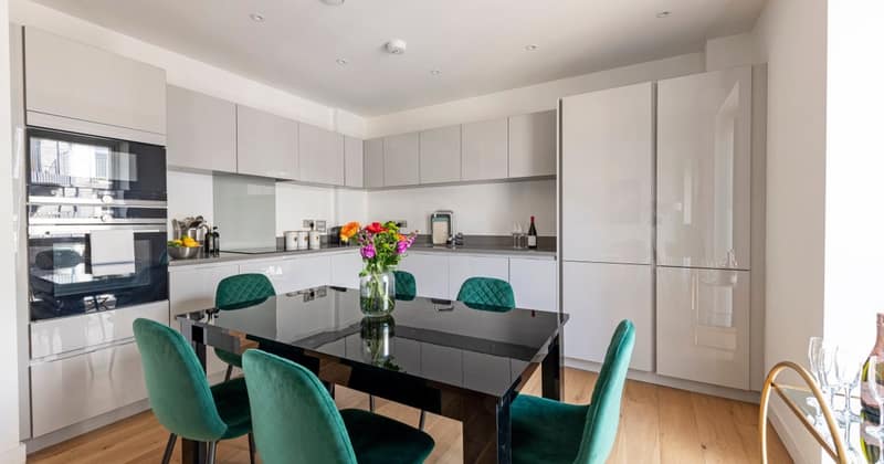 14 On Shoenix, Battersea: White kitchen with glass table and green chairs