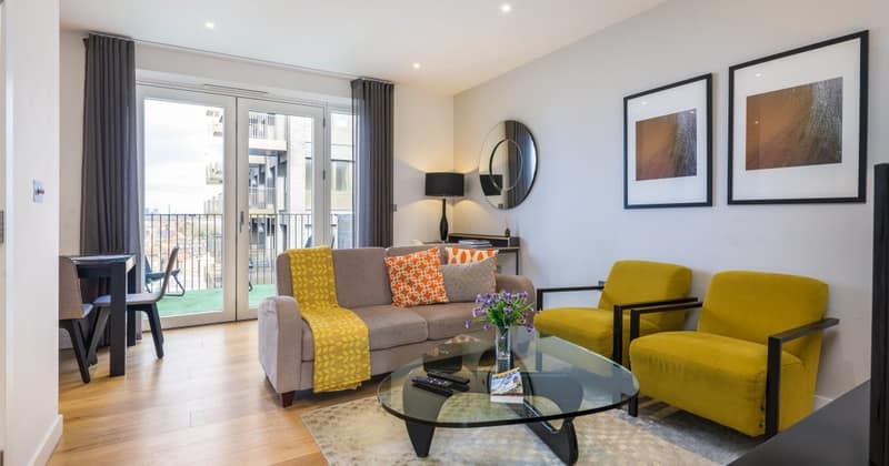 16 On Phoenix, Battersea: Yellow armchairs beside grey sofa and glass table
