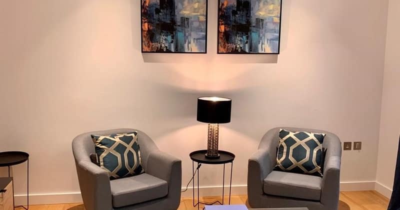 19 On Phoenix, Battersea: Two patterned armchairs beneath framed artwork