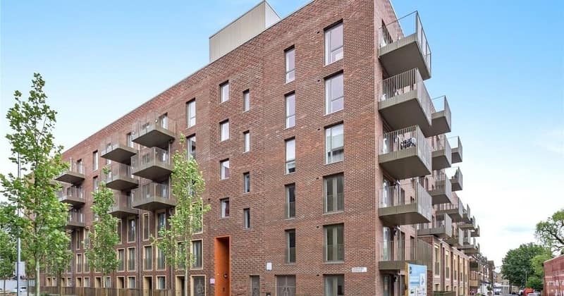 6 On Shoenix, Battersea: Brick apartment building with balconies and planted entrance