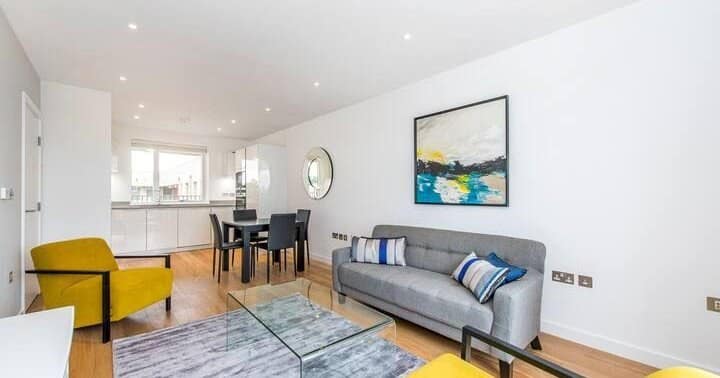 Designer Pad in Clapham Junction, Battersea: Open living room with yellow chair and kitchen