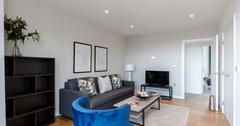 Eleven On Danvers, Battersea: Blue armchair and grey sofa opposite television