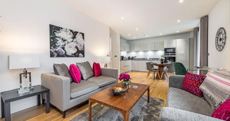 Fifteen On Sphinx, Battersea: Grey sofa with pink cushions beside coffee table