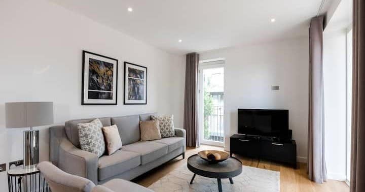 Five On Danvers, Battersea: Grey sofa and patterned cushions opposite television