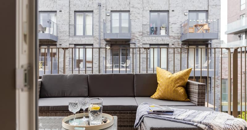 Fourteen On Sphinx, Battersea: Grey sofa in front of tall sash windows