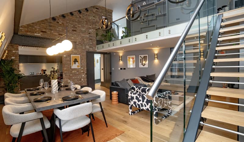 Garrick Street 52–54 Apartments, Covent Garden: Dining tables beneath exposed brick and timber ceiling