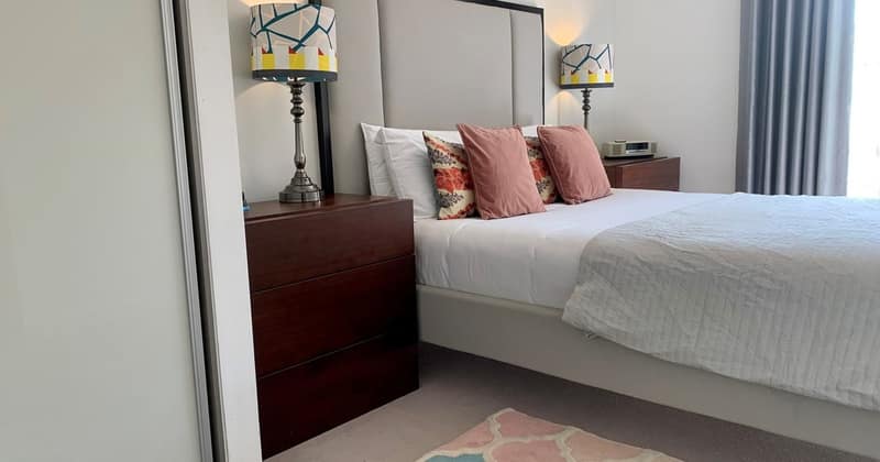 Modern Two Bed Pad, Battersea: Double bed with dark headboard and pale cushions