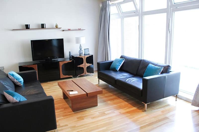 Moretonhouse Apartments, Pimlico: Black sofa opposite television in bright living room