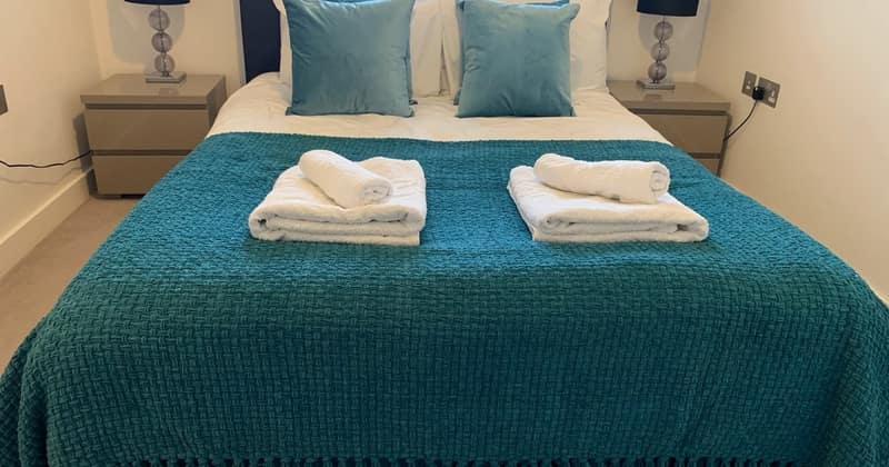 Nine On Sphinx, Battersea: Double bed with teal cover and folded towels