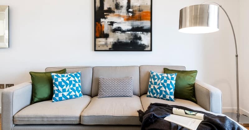 One On Danvers, Battersea: Sofa with patterned cushions beneath framed artwork