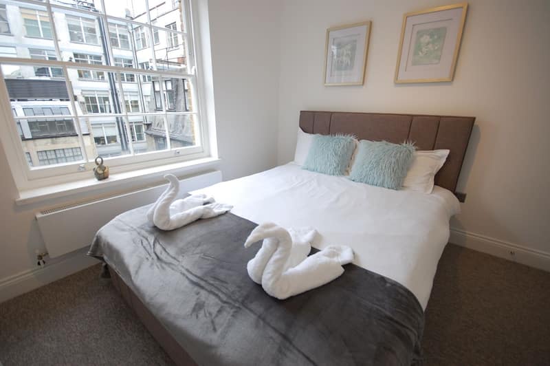 Soho Court, St Anne’s Court, Soho: Double bed beside a window with striped blind