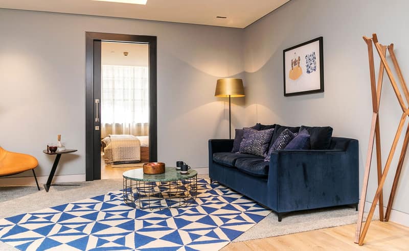 Southwark Apartments, London Bridge: Blue sofa beside patterned floor and dining area
